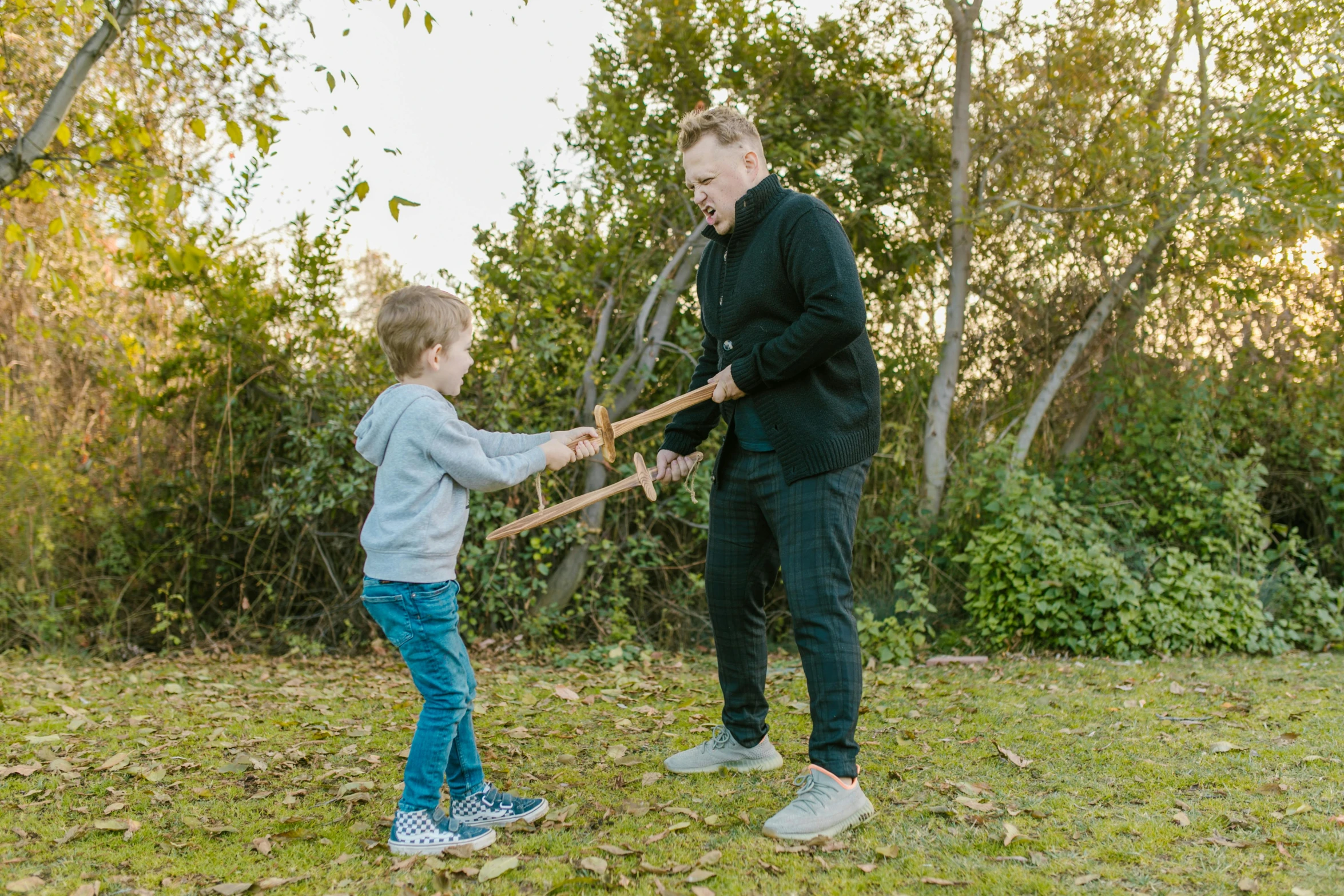 a man standing next to a little boy holding a baseball bat, pexels contest winner, practising sword stances, avatar image, outdoor photo, wooden staff