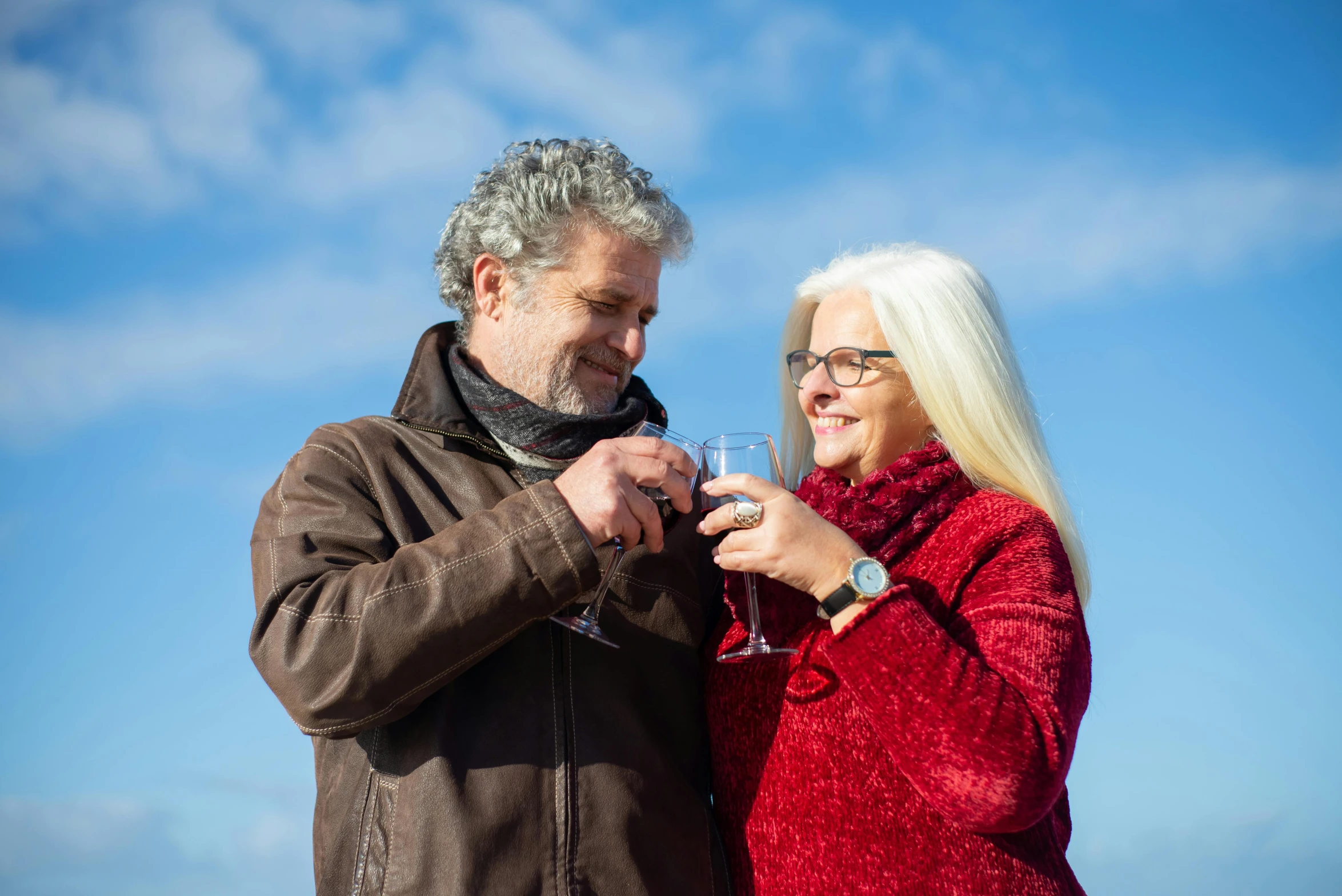 a man and woman standing next to each other holding wine glasses, by Jan Tengnagel, pexels, blue sky, bushy white beard, winter, 15081959 21121991 01012000 4k