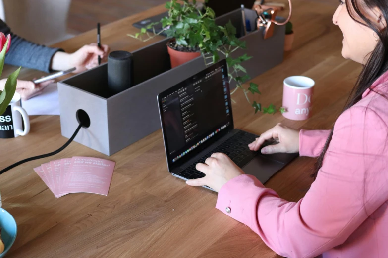 a woman sitting at a table working on a laptop, a computer rendering, by Alice Mason, pexels contest winner, box, matte black paper, pink, handcrafted