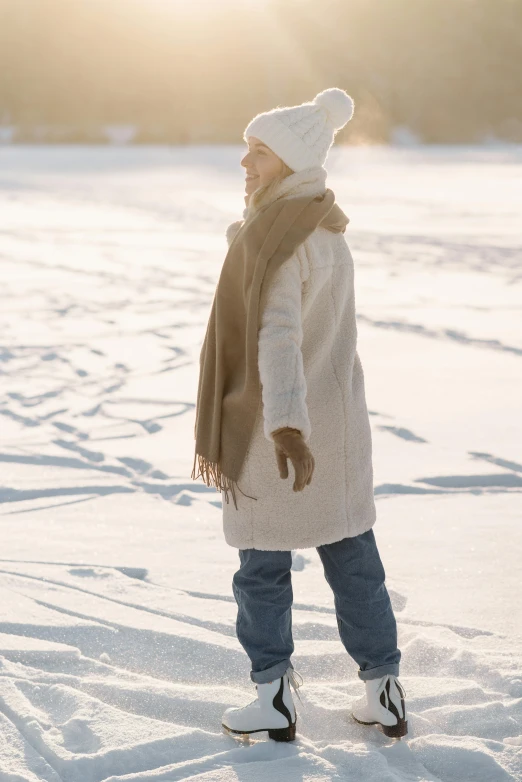 a woman walking across a snow covered field, inspired by Elsa Beskow, trending on pexels, light brown coat, little kid, background image, denim