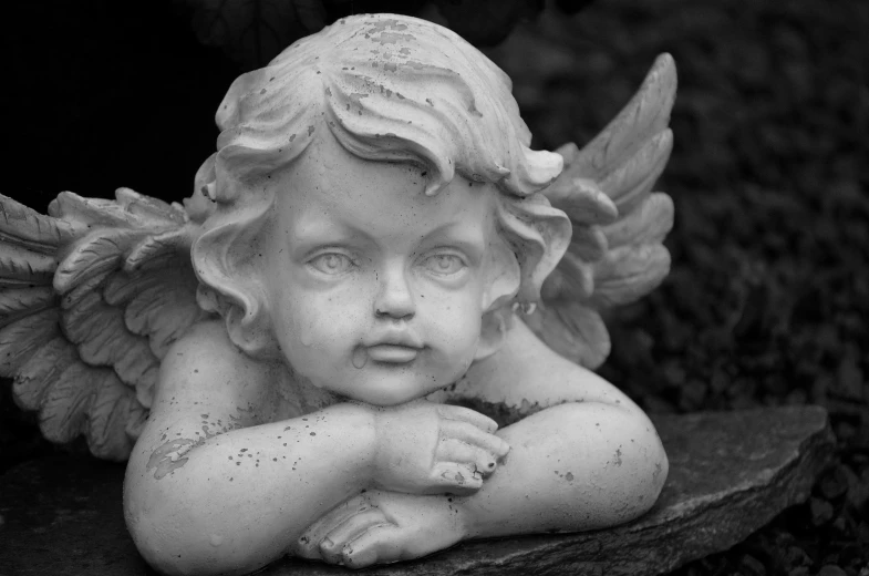 a black and white photo of a statue of an angel, pixabay, bashful expression, resting on a pillow, child, large friendly eyes
