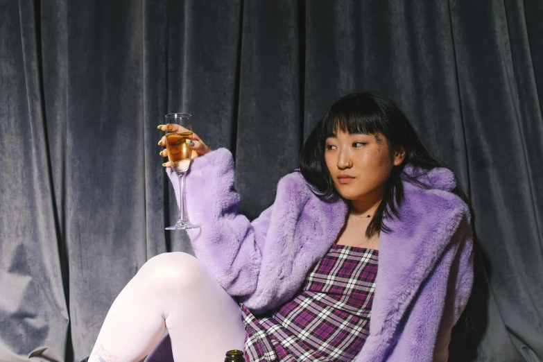 a woman sitting on a chair holding a glass of wine, trending on pexels, realism, purple jacket, japanese streetwear, purple checkerboard, asian descent