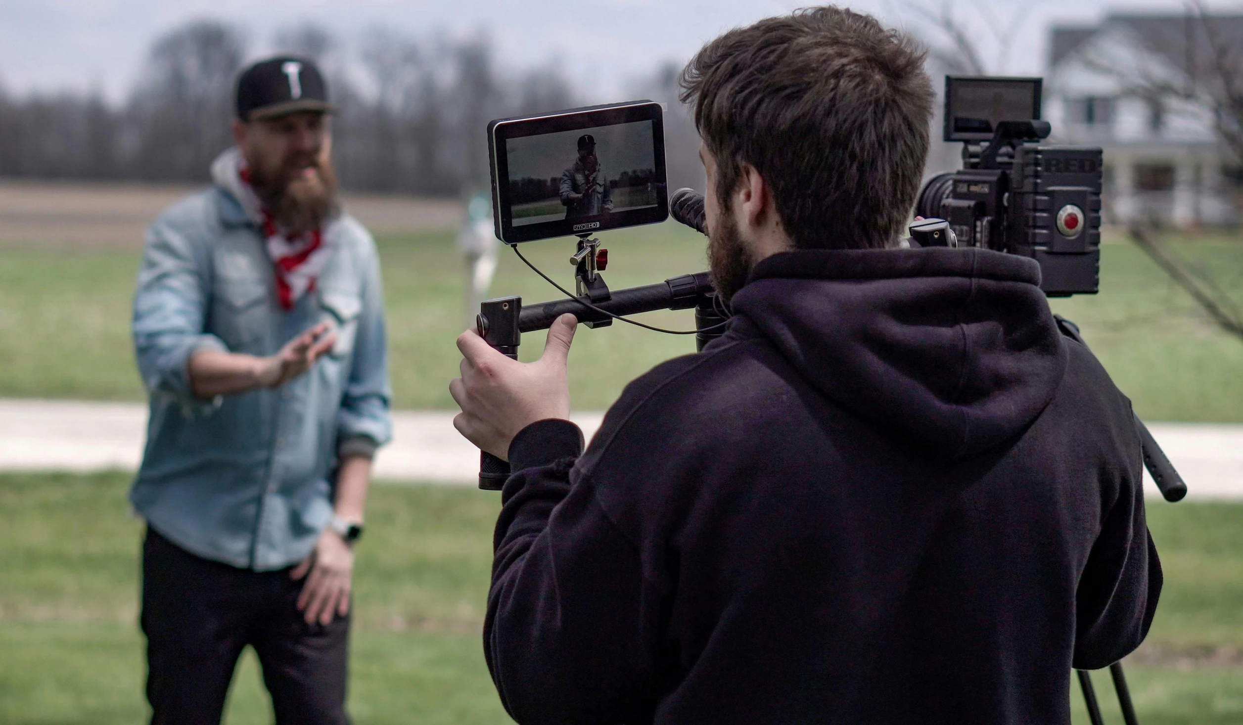 a man that is standing in front of a camera, by Ryan Pancoast, pexels, video art, person in foreground, game footage, on location, holding a microphone