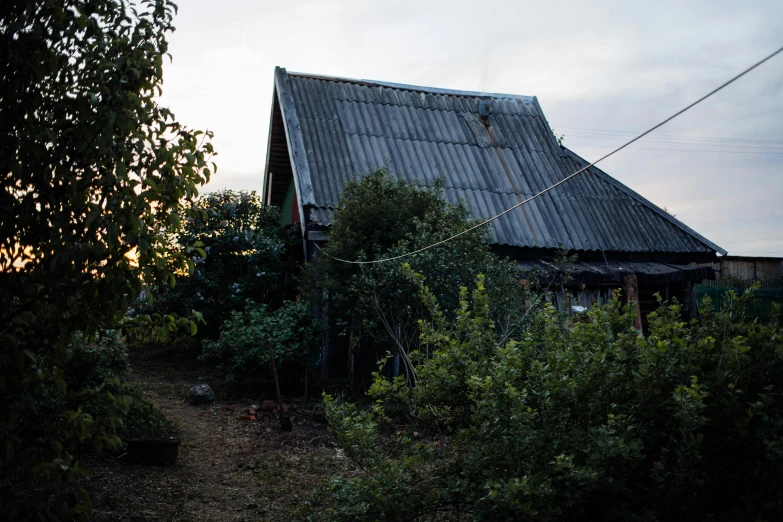 a house sitting on top of a lush green field, an album cover, unsplash, post - soviet courtyard, late summer evening, shed, фото девушка курит