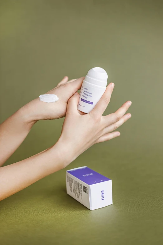 a woman holding a bottle of hand sanitizer next to a box of hand sanitizer, unsplash, bauhaus, white and purple, detailed product image, kami, back - shot