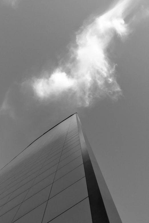 a black and white photo of a tall building, a black and white photo, inspired by Richard Wilson, light and space, smoke and clouds, tail fin, full of glass. cgsociety, summer day