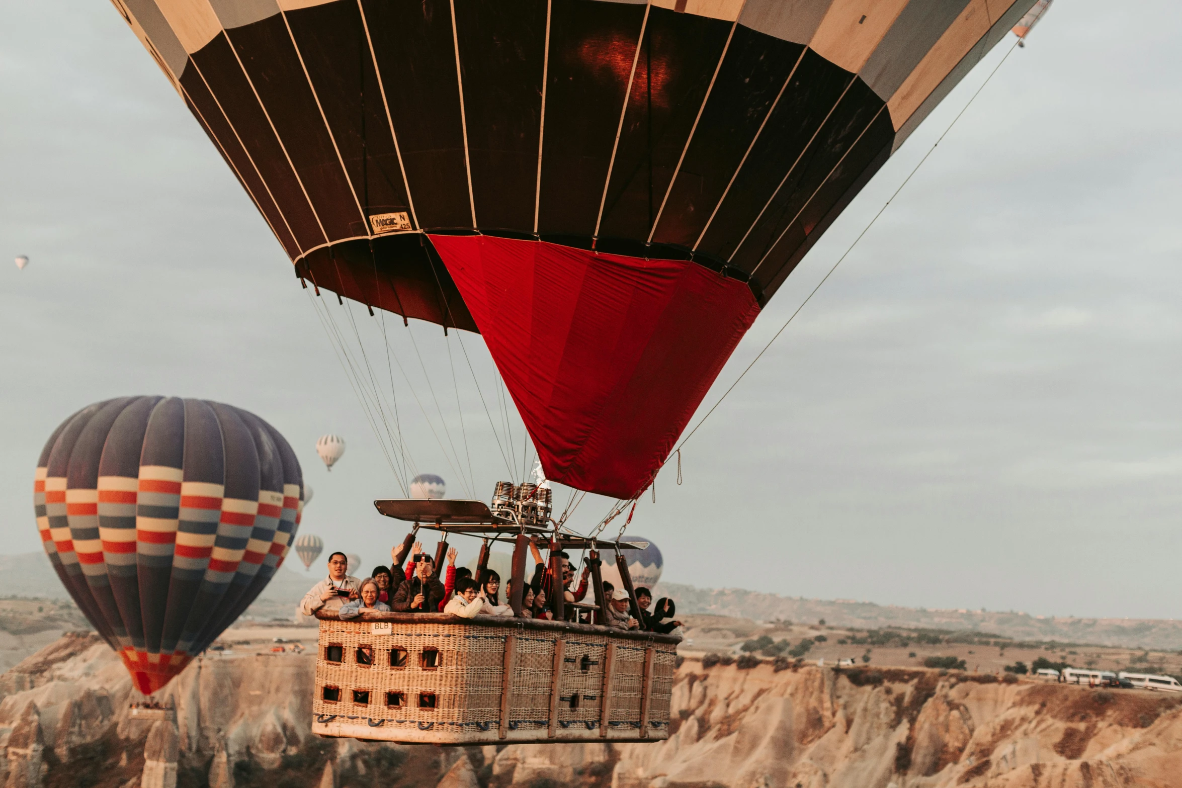 a group of people riding on top of a hot air balloon, by Jessie Algie, pexels contest winner, aykut aydogdu, hd footage, photography from vogue magazine, brown