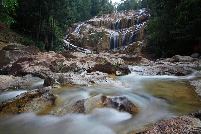 a stream running through a forest filled with rocks, by Basuki Abdullah, unsplash contest winner, hurufiyya, river flow through borneo jungle, gold waterfalls, slide show, thumbnail