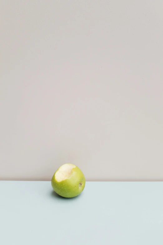 a green apple sitting on top of a table, by Harvey Quaytman, postminimalism, small chin, jovana rikalo, square, cream