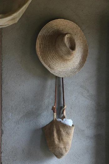 a hat and a bag hanging on a wall, inspired by Joseph Beuys, unsplash, renaissance, cottage decor, mexico, dwell, detail shot