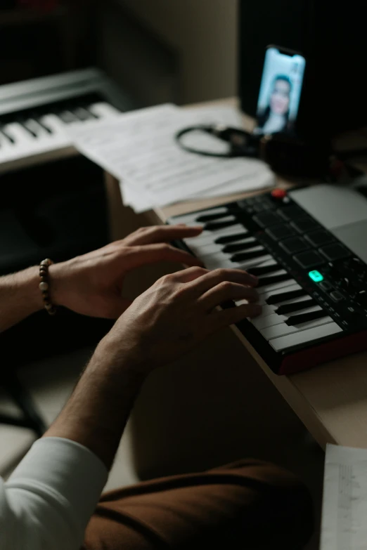 a man that is sitting in front of a keyboard, an album cover, inspired by Elsa Bleda, trending on pexels, synthetism, musicians playing instruments, studio qualit, electronics, developers