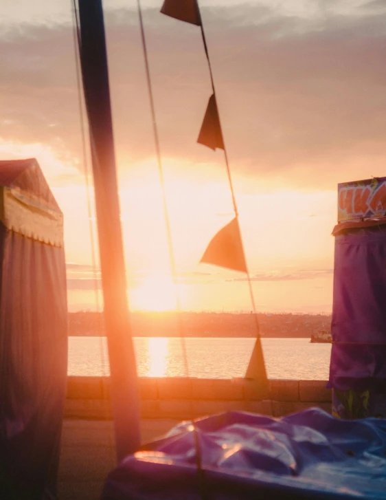 a couple of beds sitting on top of a pier, by Lee Loughridge, unsplash, happening, big top circus tent, in the golden hour, film screenshot, market stalls