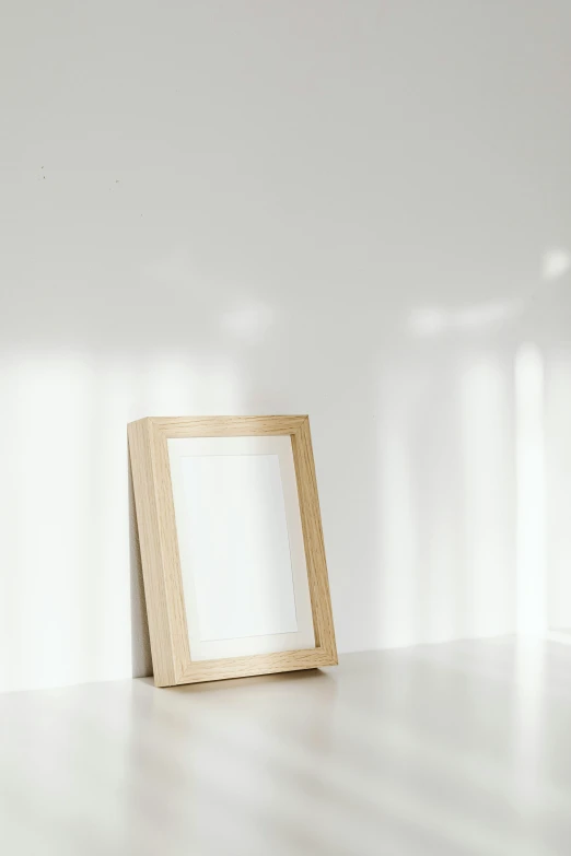 a picture frame sitting on top of a white floor, a picture, unsplash, visual art, light wood, medium blonde, sideview, blond