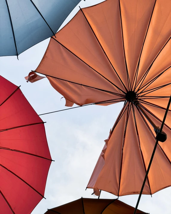 there are many different colored umbrellas in the sky, an album cover, by Rachel Reckitt, trending on unsplash, paul davey, sustainable materials, gray and orange colours, lgbtq