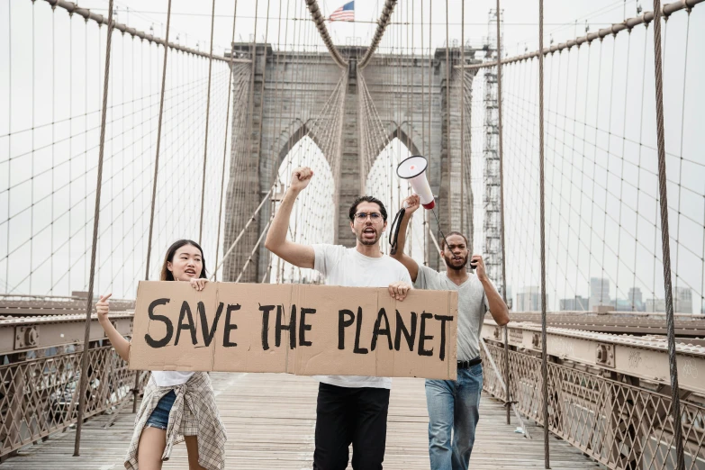 a group of people holding a sign that says save the planet, by Matija Jama, pexels contest winner, standing on a bridge, 3 - piece, nyc, venus project