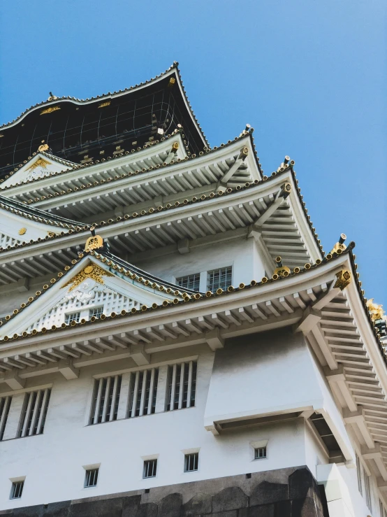 a tall white and black building under a blue sky, inspired by Kanō Shōsenin, trending on unsplash, castles and temple details, half image, thumbnail, hyper - detailed color photo