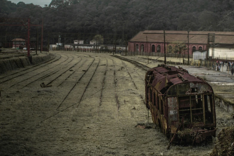 a train that is sitting in the dirt, by Elsa Bleda, pexels contest winner, auto-destructive art, old color photograph, trading depots, in sao paulo, dormant in chains