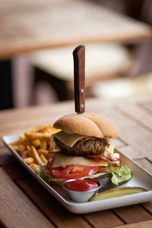 a close up of a plate of food on a table, burger on a plate, skewed shot, manly, food photography”