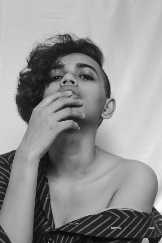 a black and white photo of a woman smoking a cigarette, inspired by irakli nadar, antipodeans, curly and short top hair, riyahd cassiem, genderless, he is about 20 years old