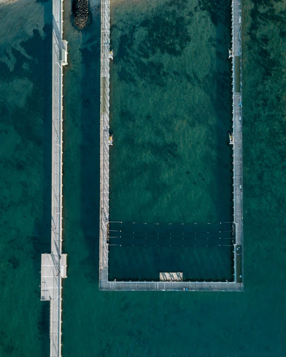 a couple of boats sitting on top of a body of water, inspired by Andreas Gursky, unsplash contest winner, minimalism, manly, pools, near a jetty, aerial