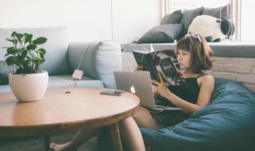 a woman sitting on a couch reading a magazine, a cartoon, pexels contest winner, korean girl, typing on laptop, two buddies sitting in a room, reading engineering book