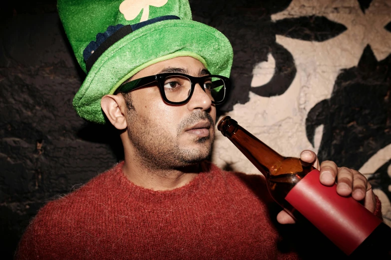 a man in a green hat drinking a beer, an album cover, pexels, navid negahban, thick rimmed glasses, clover, pose 1 of 1 6