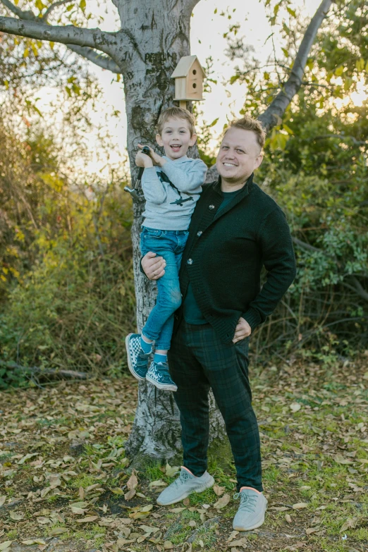 a man and a child standing in front of a tree, professional photo shoot, avatar image, ryan church, low quality photo