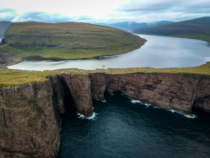 a large body of water next to a cliff, by Hallsteinn Sigurðsson, pexels contest winner, les nabis, sinkholes, orkney islands, air shot, 2 0 0 0's photo