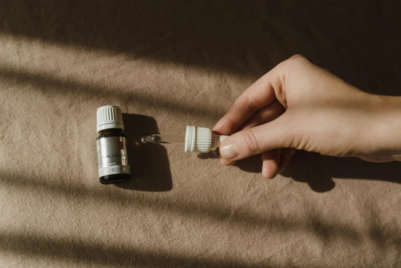 a person holding a toothbrush next to a bottle of toothpaste, by Emma Andijewska, trending on pexels, dripping oil, hibernation capsule close-up, a high angle shot, miniature product photo