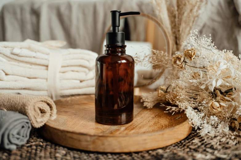 a bottle of lotion sitting on top of a wooden tray, by Andries Stock, pexels contest winner, brown resin, sienna, full-body, handmade