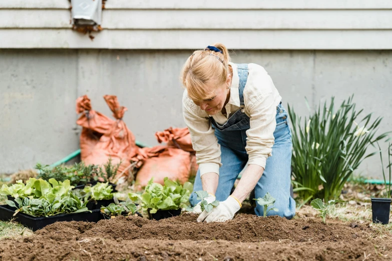 a woman that is kneeling down in the dirt, with a garden, profile image