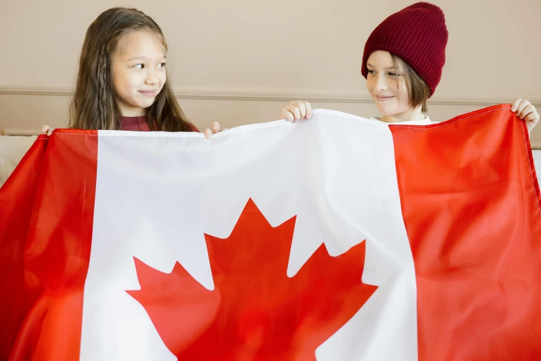 a boy and a girl holding a canadian flag, pexels contest winner, at home, pokimane, thumbnail, 1 2 9 7