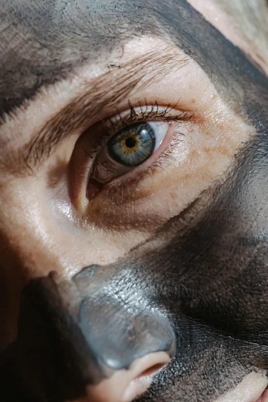 a close up of a person with a black mask on, a hyperrealistic painting, inspired by Odd Nerdrum, trending on pexels, hyperrealism, eyes of corporaptor hominis, with grey skin, heavy pigment, a high angle shot