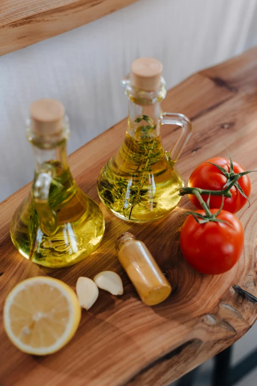 a couple of bottles of olive oil sitting on top of a wooden table, by Julia Pishtar, pexels, tomatoes, fancy dressing, salad, holiday