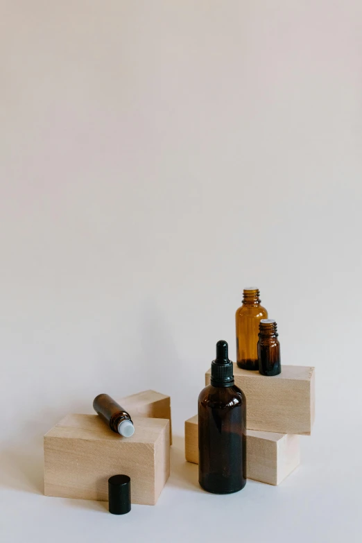a couple of bottles sitting on top of a wooden block, unsplash, visual art, skincare, display case, dwell, brown