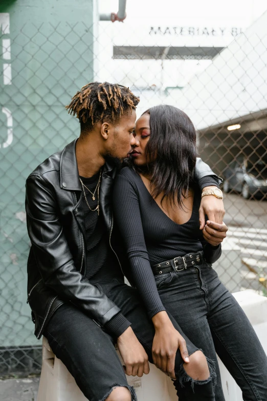 a man and a woman sitting next to each other, by Washington Allston, trending on pexels, making out, casual black clothing, brown skinned, embracing