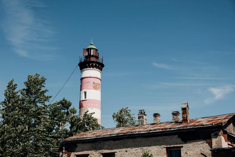 a red and white lighthouse sitting on top of a brick building, by Julia Pishtar, les nabis, tallinn, pink, high quality photo, summertime