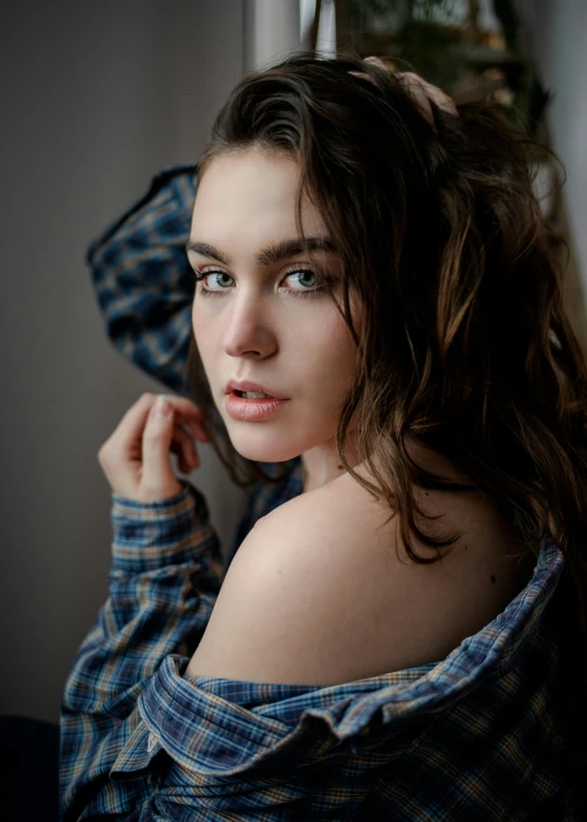 a beautiful young woman sitting next to a window, a picture, by irakli nadar, trending on unsplash, photorealism, robe. perfect faces, wearing a flannel shirt, no makeup wavy hair, with blue eyes