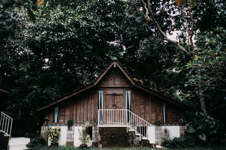 a small wooden house sitting on top of a lush green field, an album cover, unsplash, sumatraism, wedding, in a tropical forest, exterior view, barn