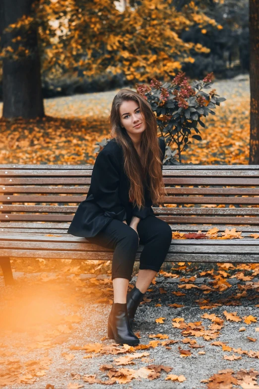 a woman sitting on a bench in a park, pexels contest winner, casual black clothing, 🍂 cute, brown colored long hair, scandinavian