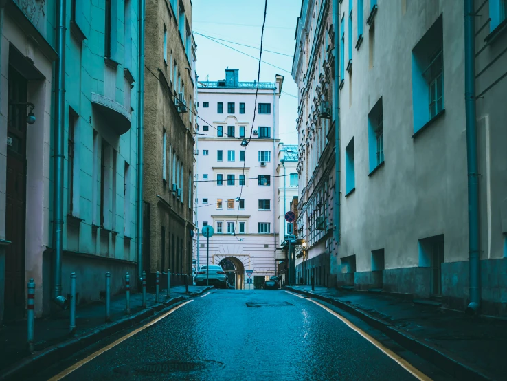 a narrow city street lined with tall buildings, inspired by Elsa Bleda, unsplash contest winner, neoclassicism, kremlin, 90s photo, fan favorite, street of teal stone