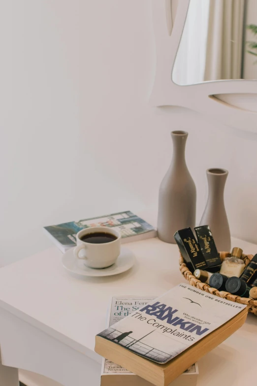 a white table topped with a book and a cup of coffee, hotel room, chocolate, aesthetic details, in white room