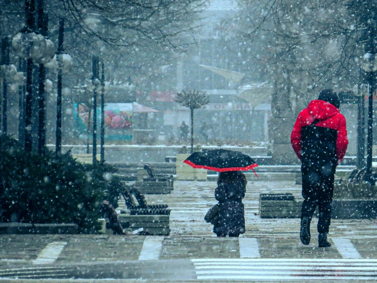 a couple of people that are walking in the snow, by Lucia Peka, pexels contest winner, red umbrella, thumbnail, slightly pixelated, in karuizawa