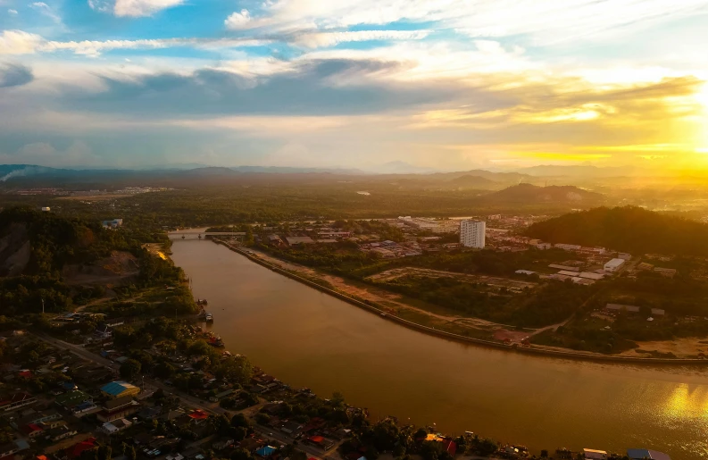an aerial view of a city and a river, pexels contest winner, sumatraism, setting sun. golden hour, extreme panoramic, aerial footage, brown