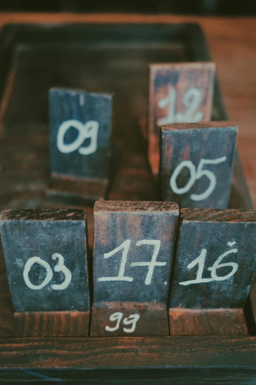 a close up of wooden blocks with numbers on them, by Elsa Bleda, unsplash, rustic setting, instagram story, blackboard, 1 7 9 5