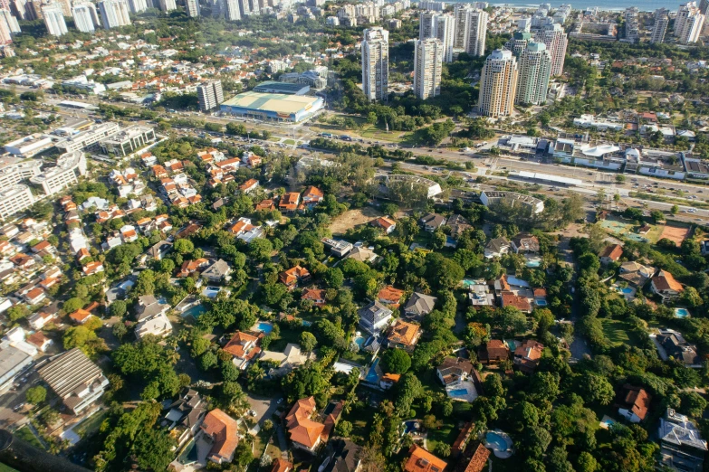 an aerial view of a city with tall buildings, by Felipe Seade, shutterstock, oscar niemeyer, houses, lush surroundings, 1980s photo