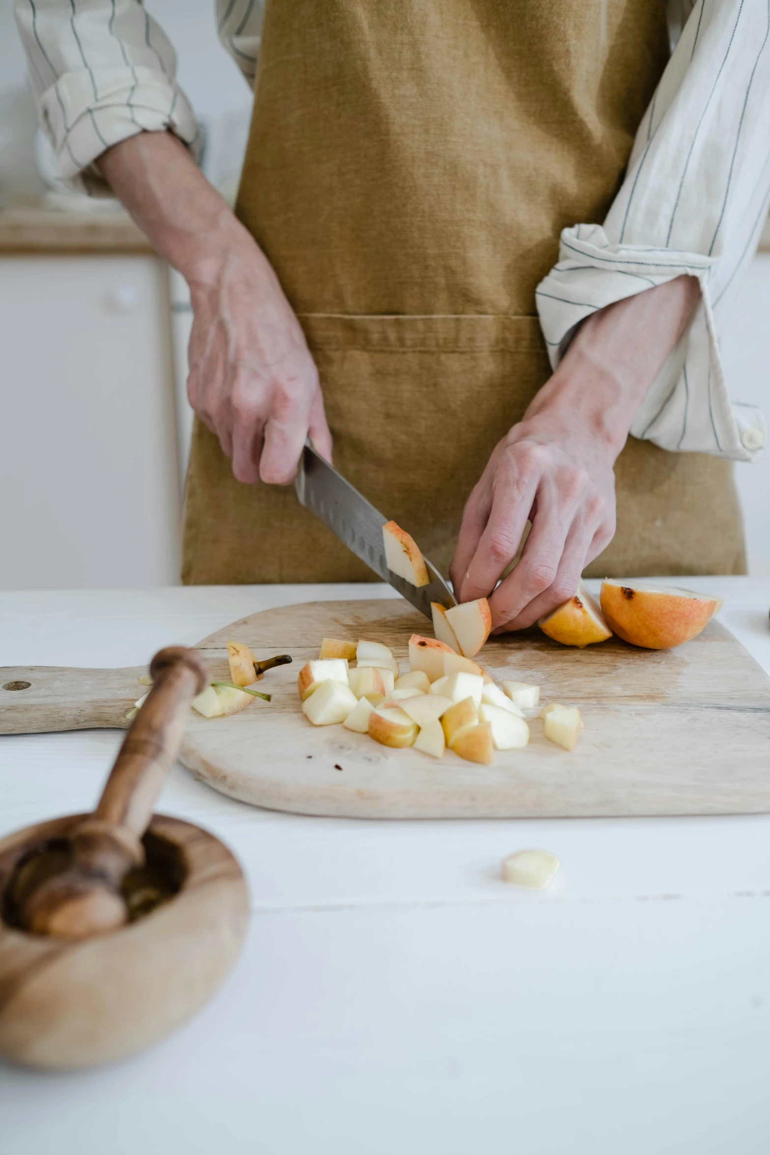 a close up of a person cutting food on a cutting board, a still life, by Jessie Algie, peeled oranges, apron, on a canva, 4l