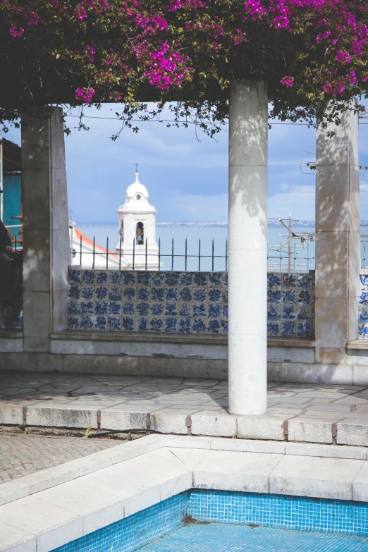 a man standing next to a swimming pool, trending on unsplash, graffiti, gigantic pillars and flowers, nazare (portugal), gazebos, view over city