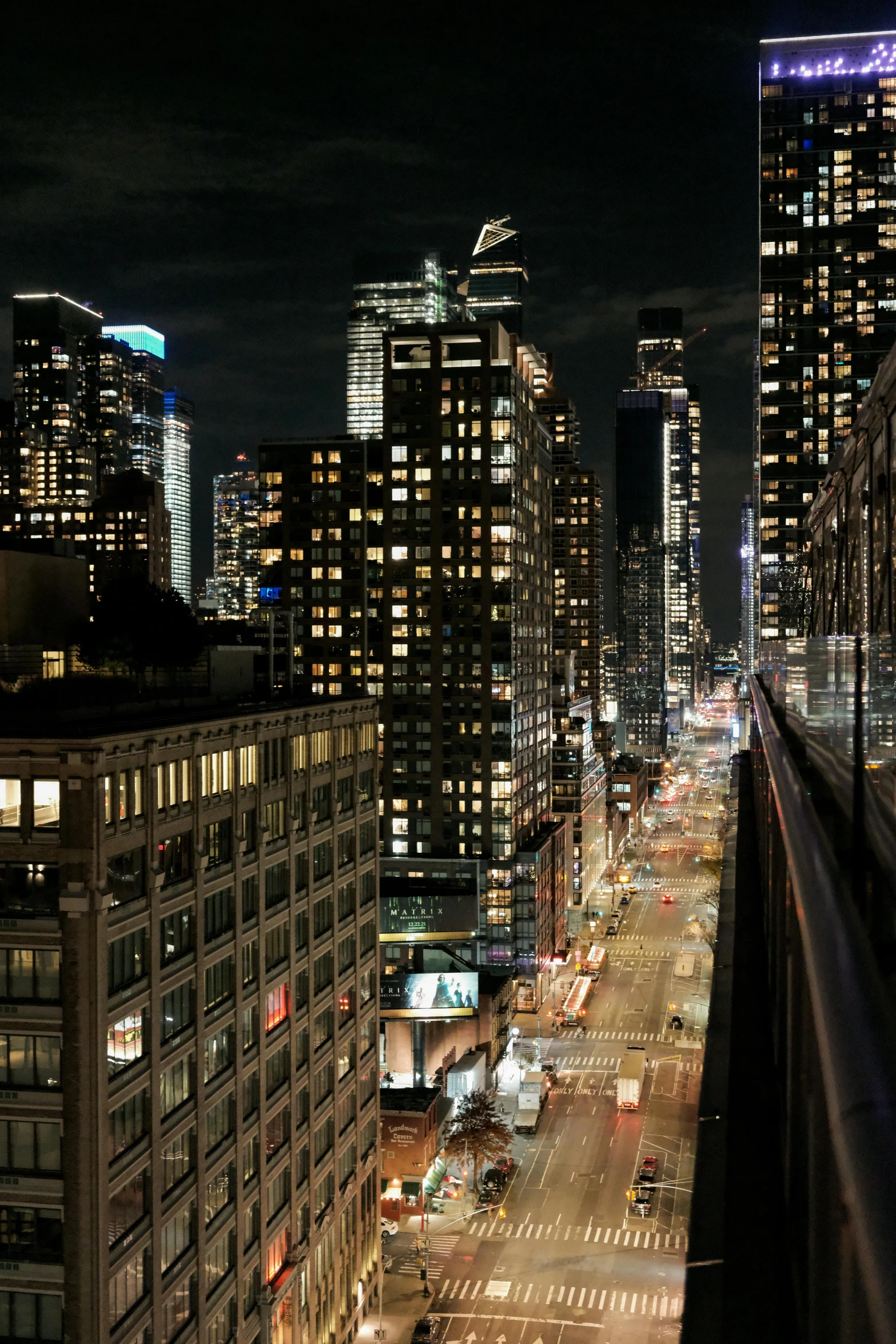 a train traveling through a city next to tall buildings, new york city at night, rooftop, looking out, slide show