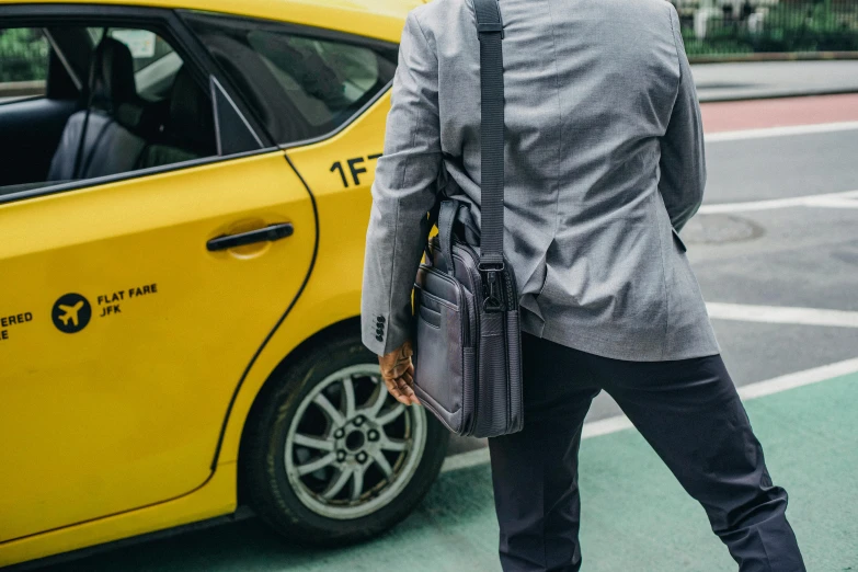 a man standing in front of a yellow taxi, happening, briefcase, gray canvas, profile image, tailored clothing